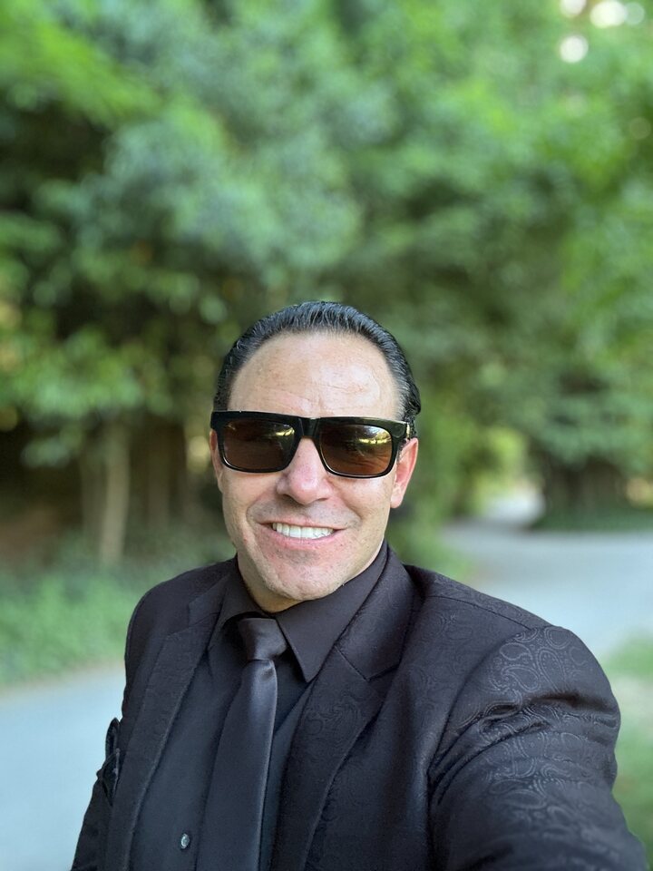 Michael Jannicelli smiling outdoors in a black suit